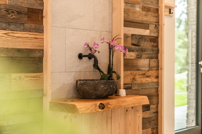 Trinkbrunnen mit Holztisch im Hotel Rösslhof