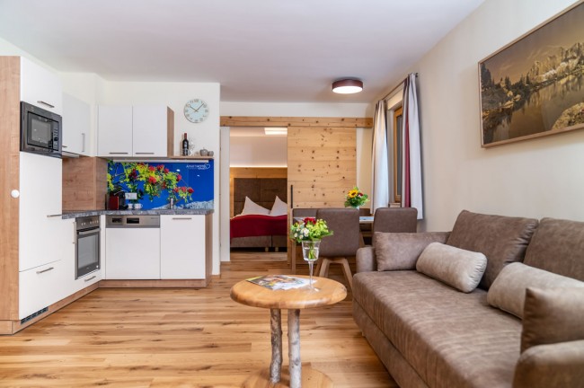 Wohnzimmer mit Küchenecke und Esstisch im Aparthotel Ramsau