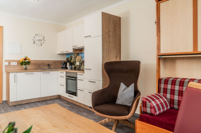 Küchenecke mit braunem Drehstuhl im Aparthotel Ramsau