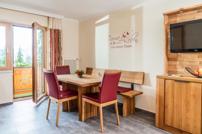 Esstisch mit roten Stühlen im Aparthotel Ramsau