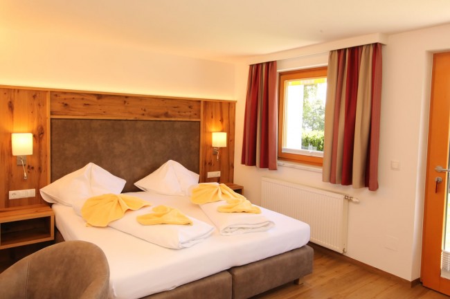 Schlafzimmer mit Doppelbett und Holzvertäfelung