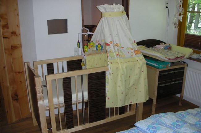 Schlafzimmer mit Wiege und Wickeltisch